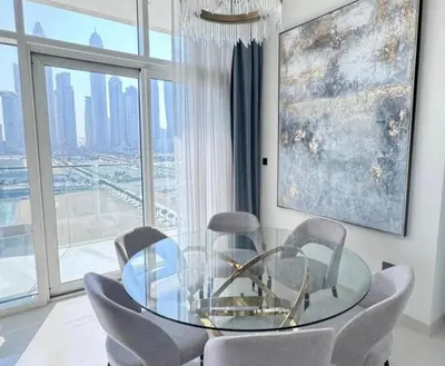 a dining room with a glass table and chairs at Dubai Harbour in Dubai