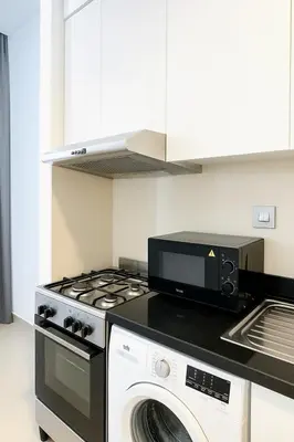 a kitchen with a stove top oven and a microwave at Dezire Delight in Dubai