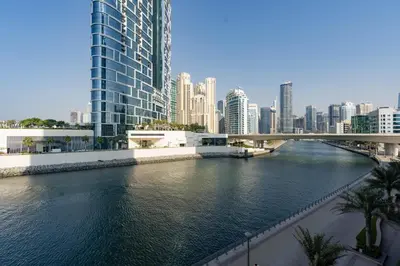 a river in a city with a bridge and buildings at Cozy and Stunning Waterfront One Bed in Dubai