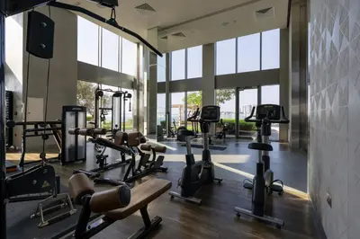 a gym with several treadmills and elliptical machines at Cozy and Stunning Waterfront One Bed in Dubai