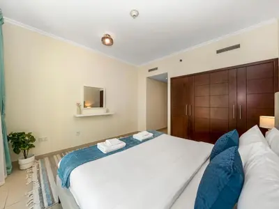 a bedroom with a large white bed with blue pillows at Prime Location - Amazing Burj Khalifa View in Dubai