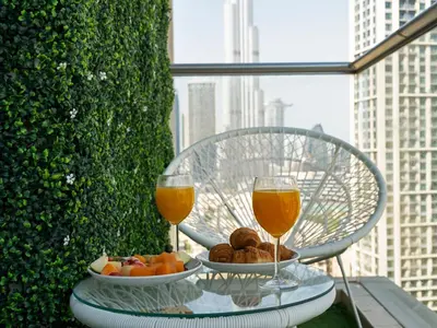 a table with a plate of fruit and two glasses of wine at Prime Location - Amazing Burj Khalifa View in Dubai