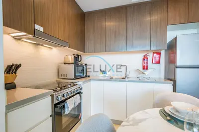 a kitchen with white cabinets and a stove top oven at Elegant 1BR in 5242 Tower 1, Dubai Marina by Deluxe Holiday Homes in Dubai