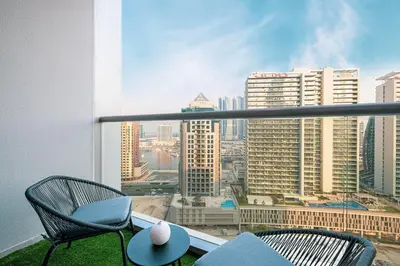 a balcony with two chairs and a view of a city at Outstanding New Studio With 2 Double Beds,In Downtown in Dubai