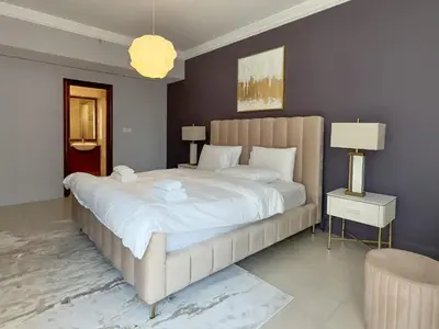 a bedroom with a large bed with white sheets at Modern Apartment in Dubai Marina in Dubai