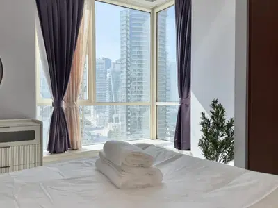 a bed with a towel on it with a large window at Modern Apartment in Dubai Marina in Dubai