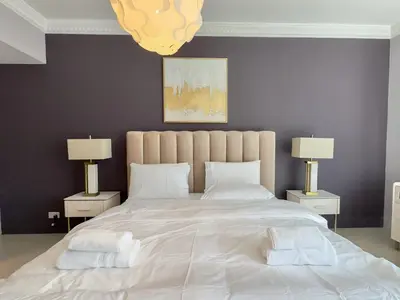 a bedroom with a large white bed with two lamps at Modern Apartment in Dubai Marina in Dubai