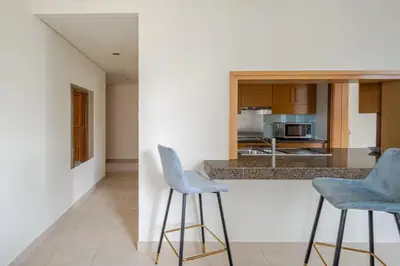 a kitchen with two blue bar stools next to a counter at 2BR Luxury Apartment in Downtown Opposite Mall and Fountain Entrance in Dubai