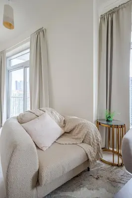 a white bedroom with a bed and a window at 2BR Luxury Apartment in Downtown Opposite Mall and Fountain Entrance in Dubai