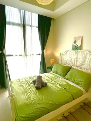 a bedroom with a green bed with a teddy bear on it at Samani vacation homes 3018 in Dubai