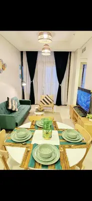 a living room with a table with plates on it at Samani vacation homes 3018 in Dubai