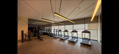 a gym with a row of treadmills and machines at Samani vacation homes 3018 in Dubai