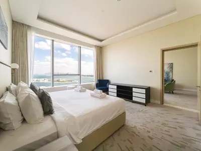 a bedroom with a large bed with a large window at SettlerHomes - Elegant Palm Tower Stay with the Sea View in Dubai