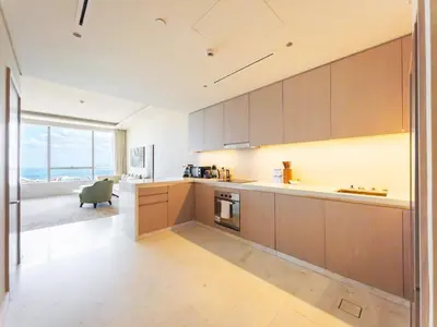 a kitchen with wooden cabinets and a view of the ocean at SettlerHomes - Elegant Palm Tower Stay with the Sea View in Dubai