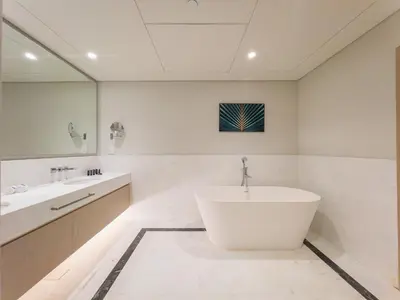 a white bathroom with a tub and a sink at SettlerHomes - Elegant Palm Tower Stay with the Sea View in Dubai