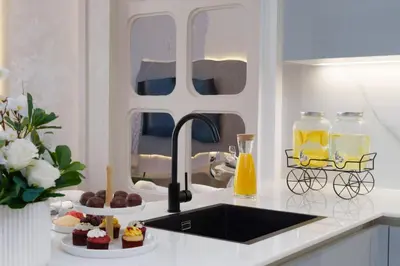 a kitchen with a sink and a counter with cupcakes at The Burj and Canal Views in Dubai