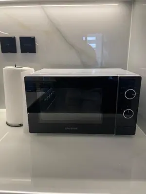 a black microwave sitting on a counter in a kitchen at The Burj and Canal Views in Dubai