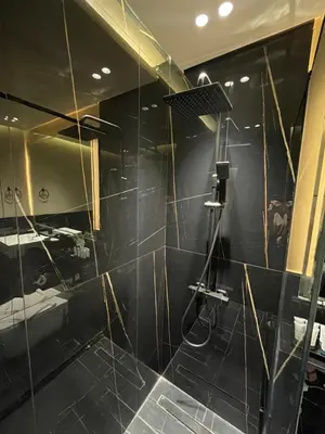 a bathroom with a shower with a glass wall at The Burj and Canal Views in Dubai