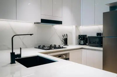 a white kitchen with a sink and a stove at 1BR Cozy and NEW brand JVC in Dubai
