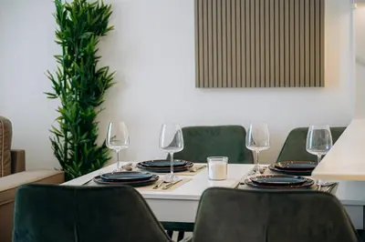 a table with chairs and wine glasses on it at 1BR Cozy and NEW brand JVC in Dubai