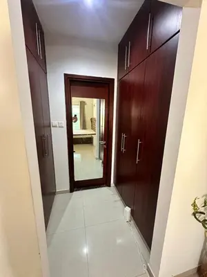 a hallway with wooden cabinets and a door to a bathroom at Bedroom with attach bath and balcony in Marina Dubai in Dubai
