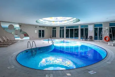 a large swimming pool in a building with a building at Bedroom with attach bath and balcony in Marina Dubai in Dubai