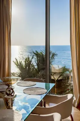 a table with chairs and a view of the ocean at Bluewaters Sea View 2BR Pool & Gym & Beachfront in Dubai
