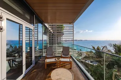 a balcony with two chairs and a view of the ocean at Bluewaters Sea View 2BR Pool & Gym & Beachfront in Dubai