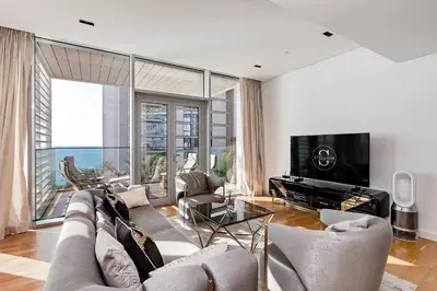 a living room with a couch and a tv at Bluewaters Sea View 2BR Pool & Gym & Beachfront in Dubai