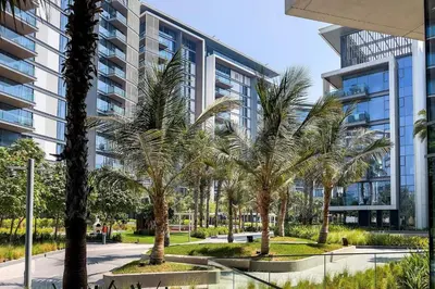 a group of palm trees in front of a building at Bluewaters Sea View 2BR Pool & Gym & Beachfront in Dubai