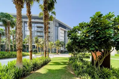 an office building with palm trees in front of it at Bluewaters Sea View 2BR Pool & Gym & Beachfront in Dubai