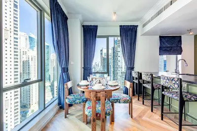 a dining room with a table and chairs and large windows at Unique JBR Gem - Full Sea View - Designer's Choice - 5 min walk from JBR Beach in Dubai