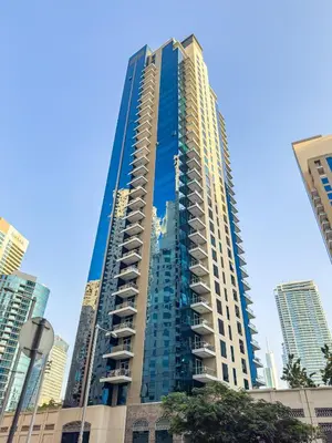 a tall blue building in a city with tall buildings at Unique JBR Gem - Full Sea View - Designer's Choice - 5 min walk from JBR Beach in Dubai
