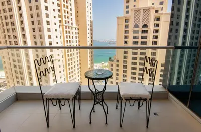two chairs and a table on a balcony with a view at Unique JBR Gem - Full Sea View - Designer's Choice - 5 min walk from JBR Beach in Dubai