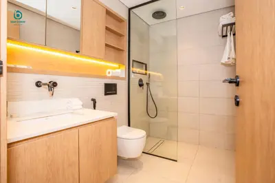 a bathroom with a toilet and a sink and a shower at Blue Breeze - Elegant 1BR with Private Jacuzzi & Terrace in JVC in Dubai