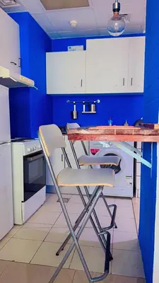 a kitchen with blue walls and a table and chairs at Aesthetic Blue Studio on Marina Walk in Dubai