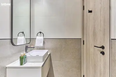a bathroom with a white sink and a mirror at bnbmehomes - Oxford Terraces in Dubai