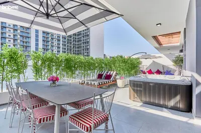 a patio with a table and chairs on a balcony at bnbmehomes - Oxford Terraces in Dubai