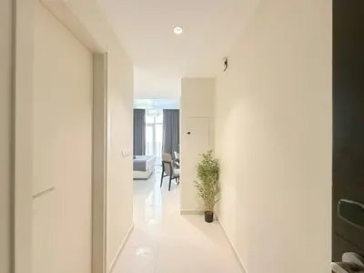 a hallway leading to a living room with white walls at Bespoke Holiday Homes - High floor studio in Tower 108 JVC in Dubai
