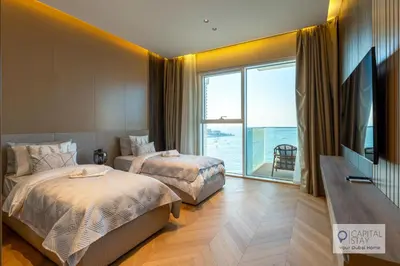 a hotel room with two beds and a large window at Luxury Beachfront 3 Bed Apt in Dubai JBR in Dubai