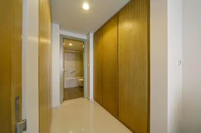 a hallway with a bathroom with a toilet and wooden walls at Higher Floor 2BR in Aykon City Discounted Prices in Dubai