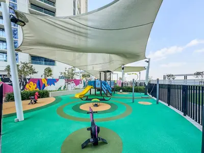 a playground with a slide and a swing at Higher Floor 2BR in Aykon City Discounted Prices in Dubai