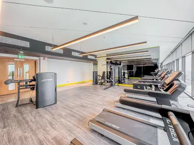 a gym with a row of treadmills at Higher Floor 2BR in Aykon City Discounted Prices in Dubai
