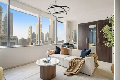 a living room with a white couch and a large window at Silkhaus Cozy Studio at Sky Gardens-Heart of DIFC in Dubai