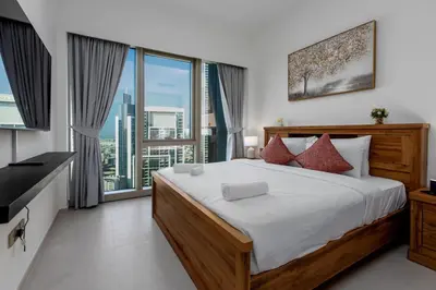 a bedroom with a large bed and a large window at Brand New 1BR Apt in Grande Residence, Downtown Dubai - Allsopp & Allsopp in Dubai
