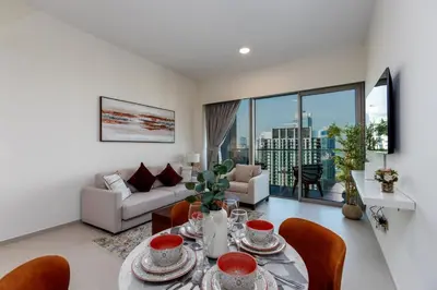 a living room with a table and chairs and a couch at Brand New 1BR Apt in Grande Residence, Downtown Dubai - Allsopp & Allsopp in Dubai