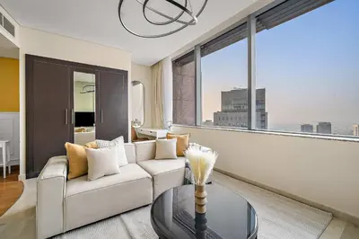 a living room with a white couch and a large window at Silkhaus Sky Gardens at Homestyle Studio in DIFC in Dubai