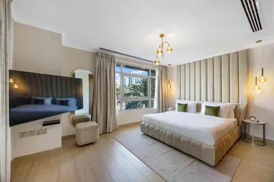 a hotel room with a bed and a tv at Durrani Homes - Azure 2BR with Burj Khalifa and Fountain View in Dubai