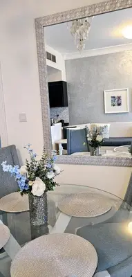 a living room with a mirror and tables and chairs at Superb 1 BR apt next to Burj Khalifa and Dubai mall in Dubai