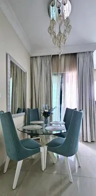 a dining room with a glass table and blue chairs at Superb 1 BR apt next to Burj Khalifa and Dubai mall in Dubai